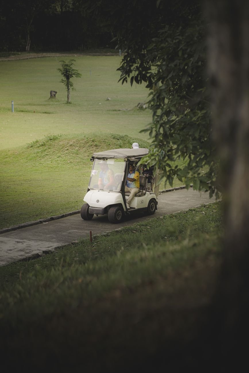 Golf cart driving along a sunny course path