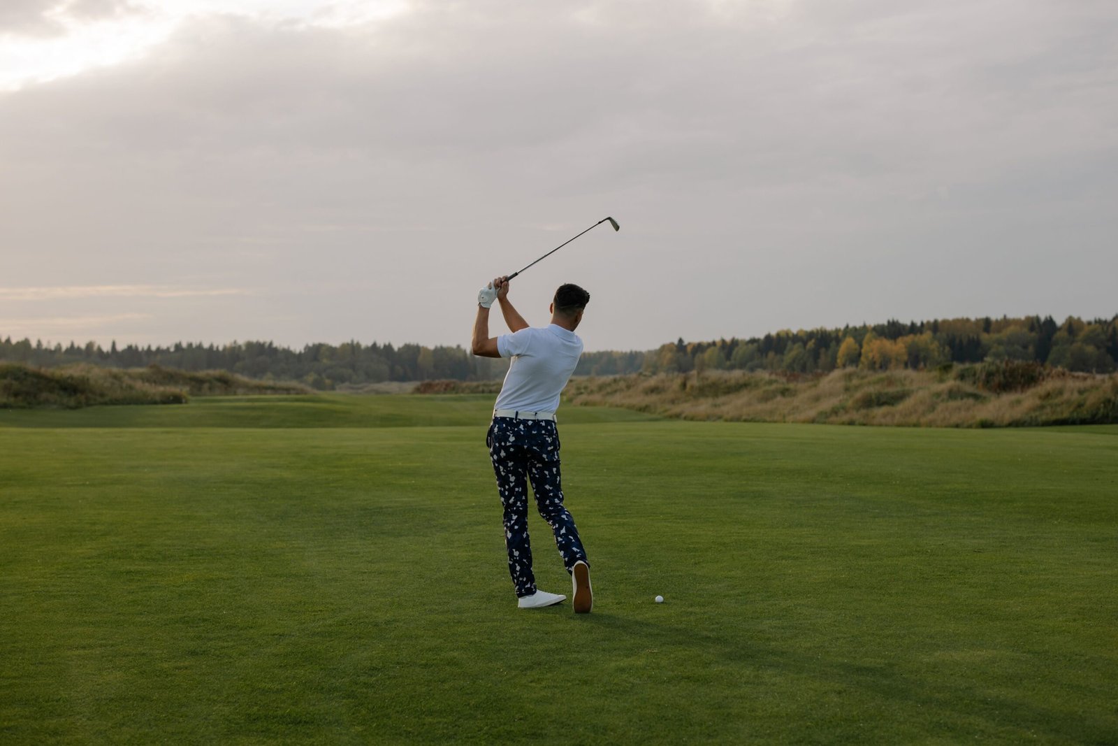 Golfer addressing the ball with a fairway wood on the fairway