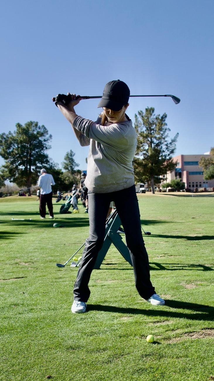 Golfer finishing in a balanced, stacked position instead of a reverse C golf swing