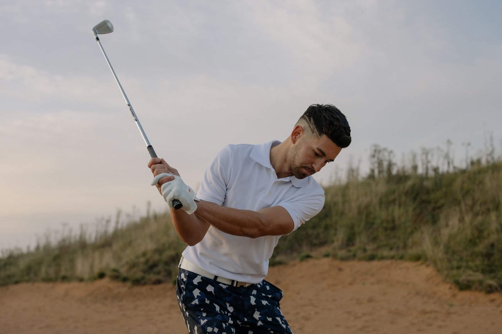 Focused golfer mid-swing, showing the twisting motion that makes golfing with a hernia risky before it heals