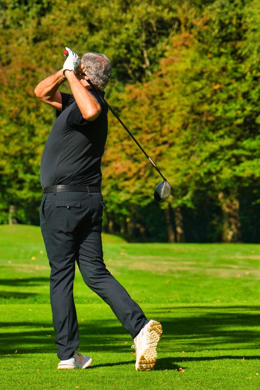 Golfer perfecting swing form on a sunny golf course