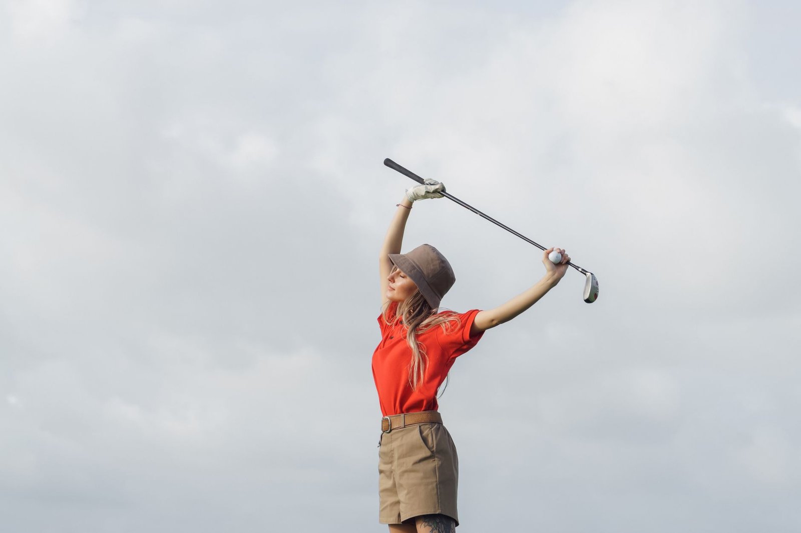 Senior golfer stretching with a golf club before a round to warm up the shoulder