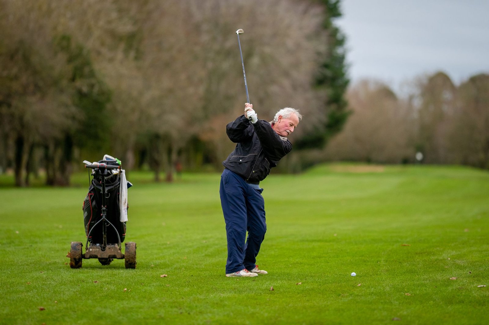 Senior golfer swinging on the course, one of the groups that benefits most from the best knee brace for golf