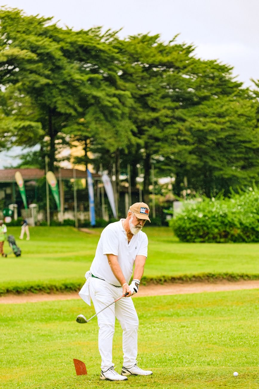 Senior man completing a golf swing on a sunny course, testing a lighter swing weight setup