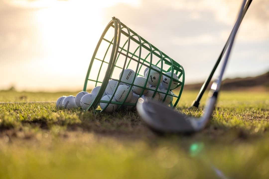 Golf clubs and balls lined up on a driving range for practice drills