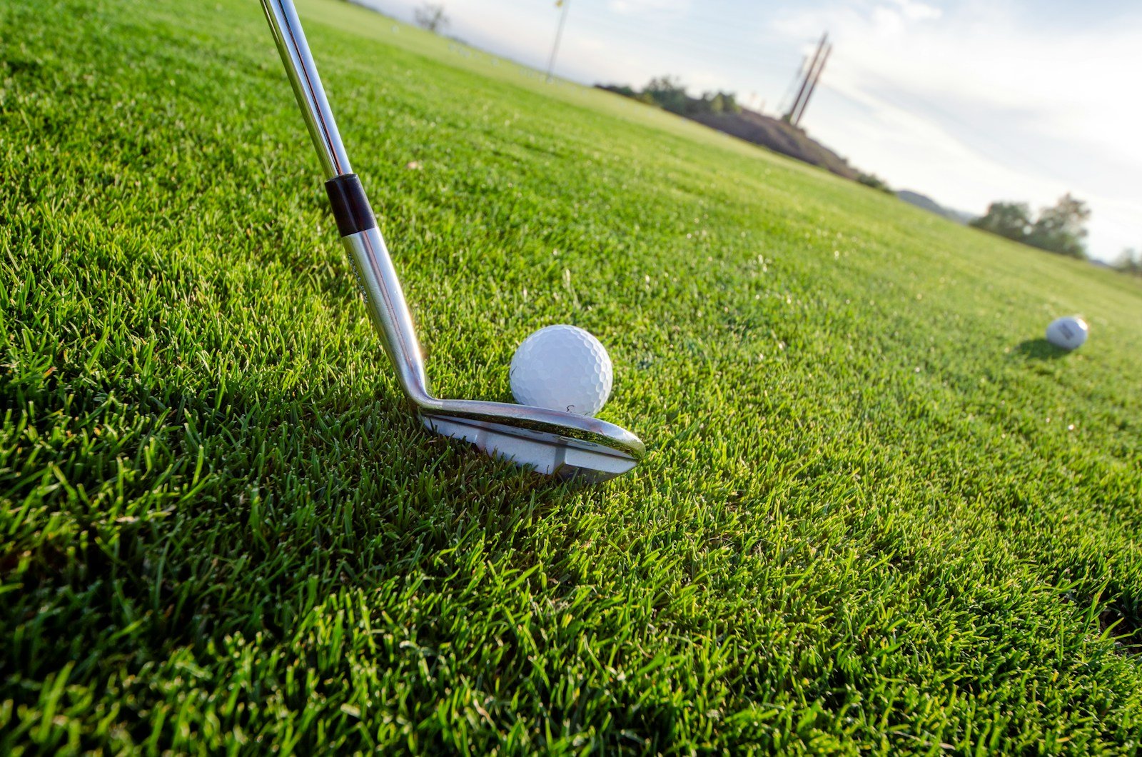 close-up of a golf iron clubhead resting in the grass