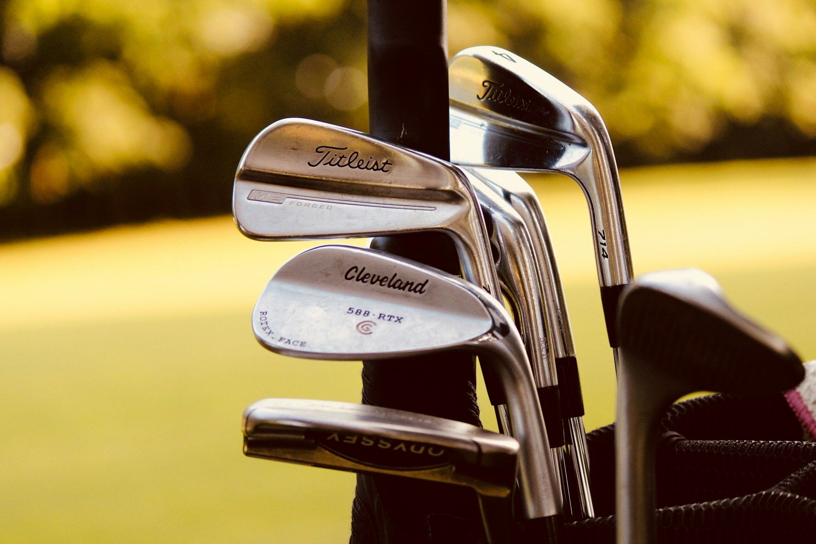 Selective focus photo of gray steel golf club shafts and grips