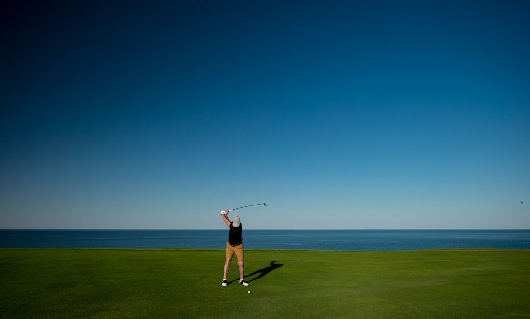golfer finishing the follow through of a golf swing after exhaling through impact