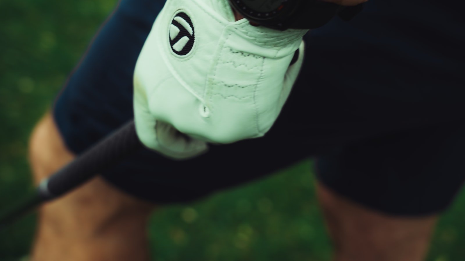 Close-up of a golfer's gloved hand gripping a golf club with a properly sized grip