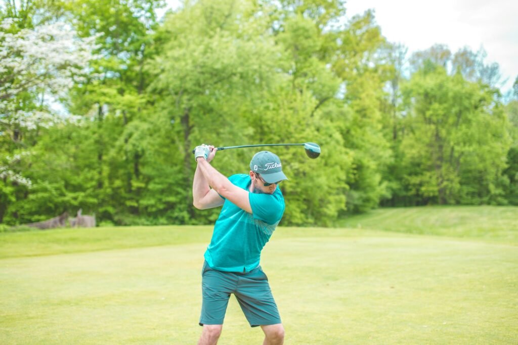 Golfer striking the ball with weight centered over the front foot, the position the stack and tilt golf swing for seniors emphasizes