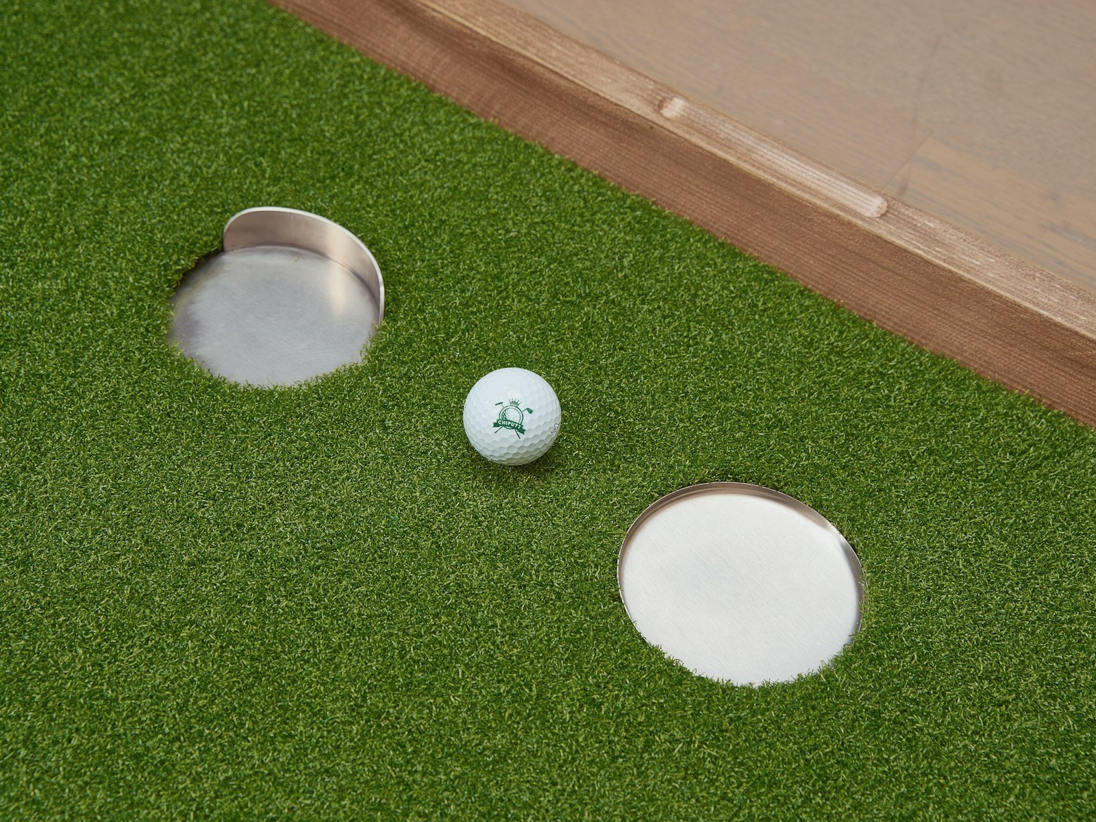 One of the best golf alignment aids for putting: a ball centered between practice cups on the green