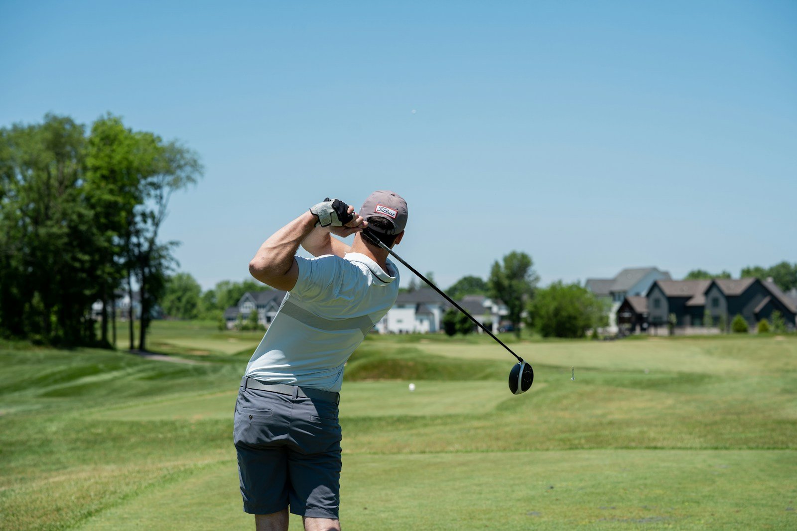 Golfer at address setting foot alignment, the starting point for a closed stance in the golf swing