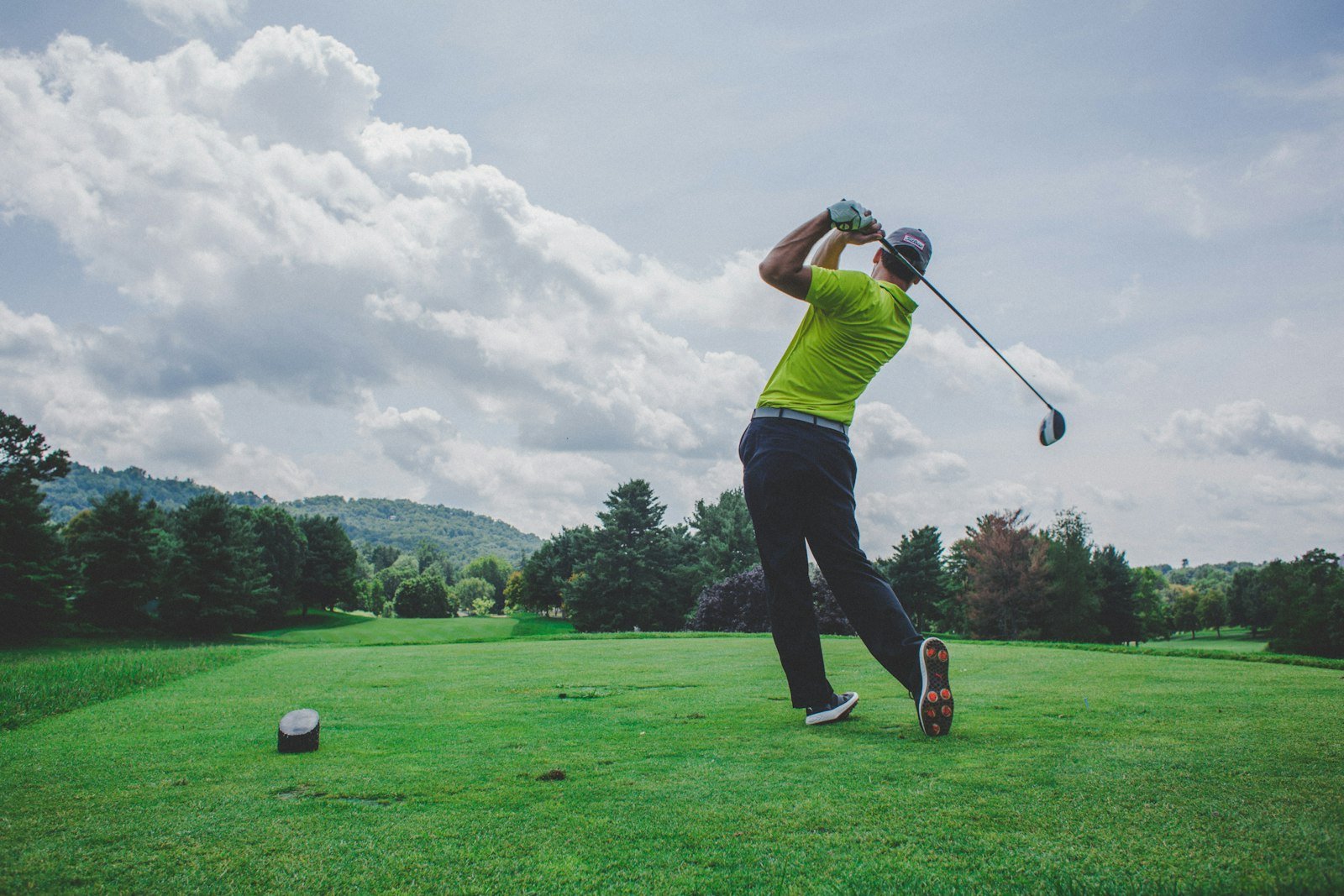 Golfer swinging one of the best golf clubs for seniors on a sunny fairway
