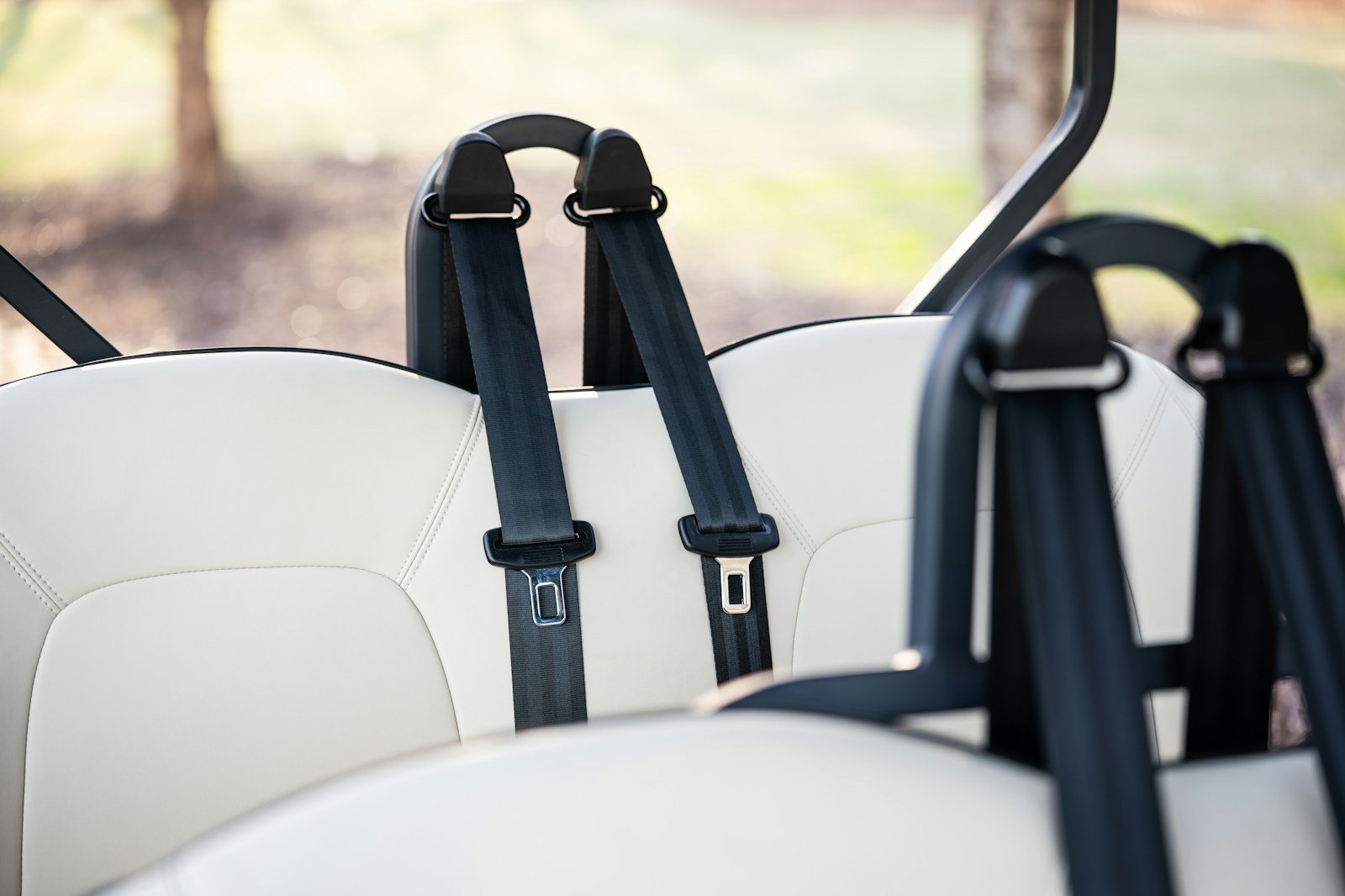 Close-up of golf cart bench seats with seatbelts