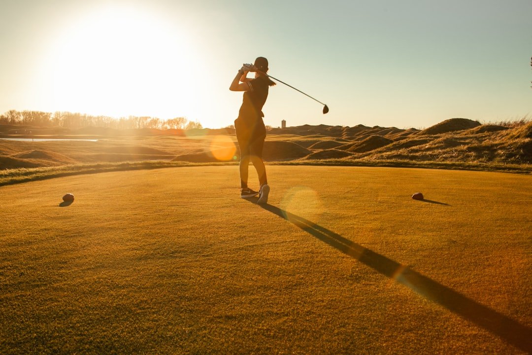 Golfer teeing off with a driver, the lowest lofted golf club in the bag