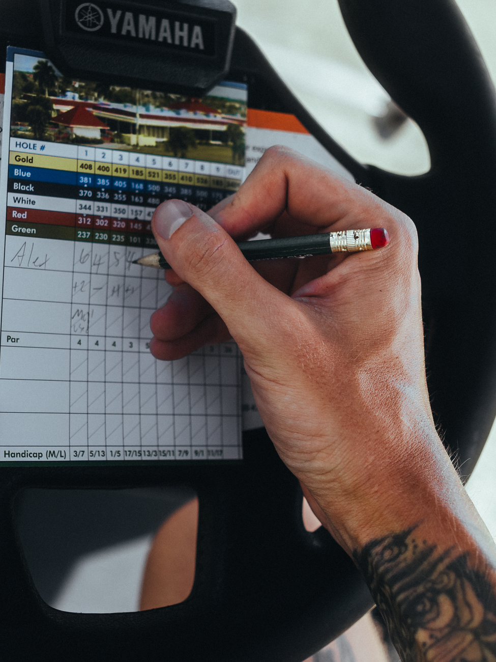 Golfer marking a low net golf score on a scorecard after applying handicap strokes