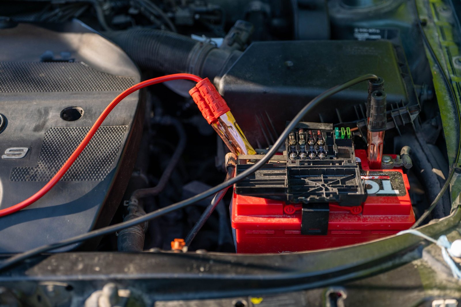Jumper cables clipped to a battery terminal, the same boost method used to wake up a dead golf cart battery before a charger will engage