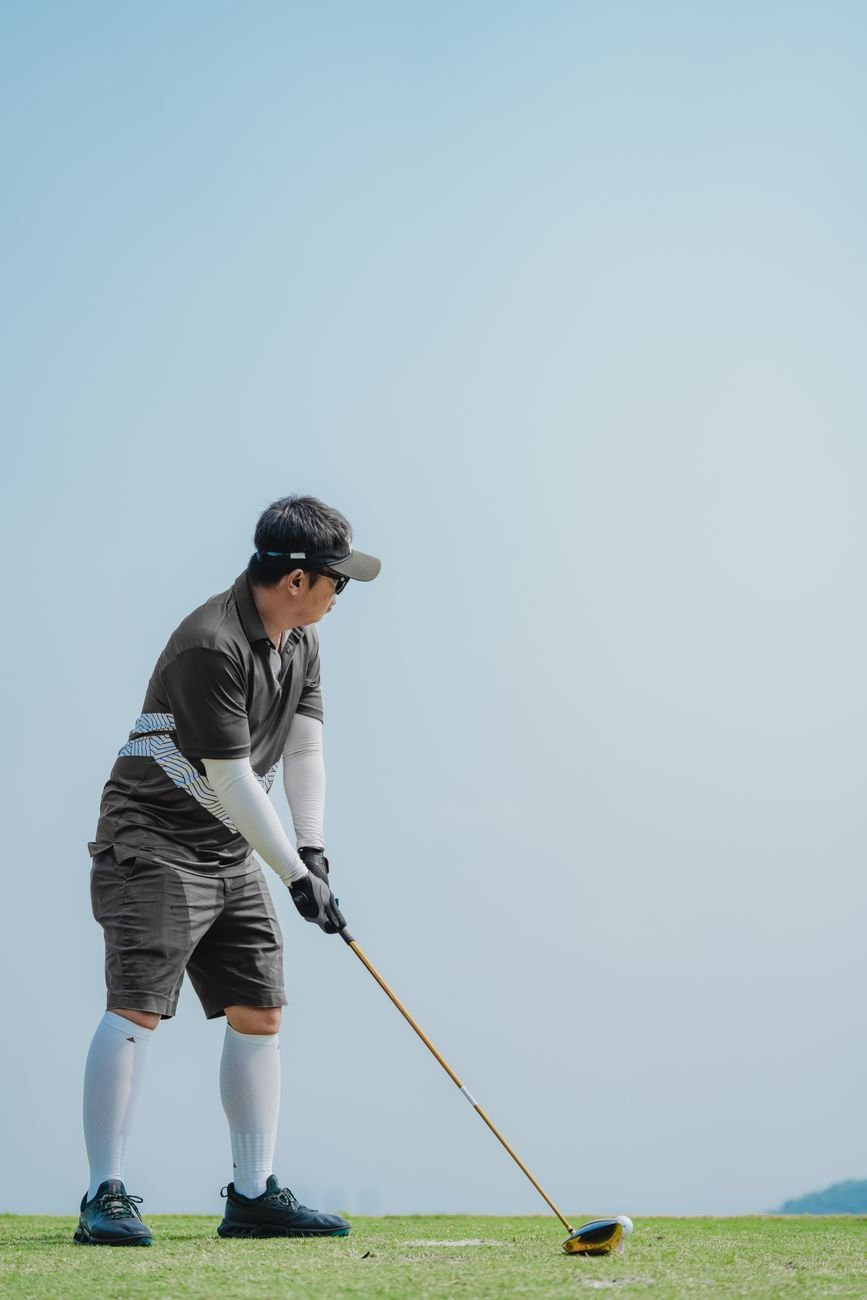 Golfer at the top of the backswing, the same shoulder turn seen in Caitlin Clark's golf swing