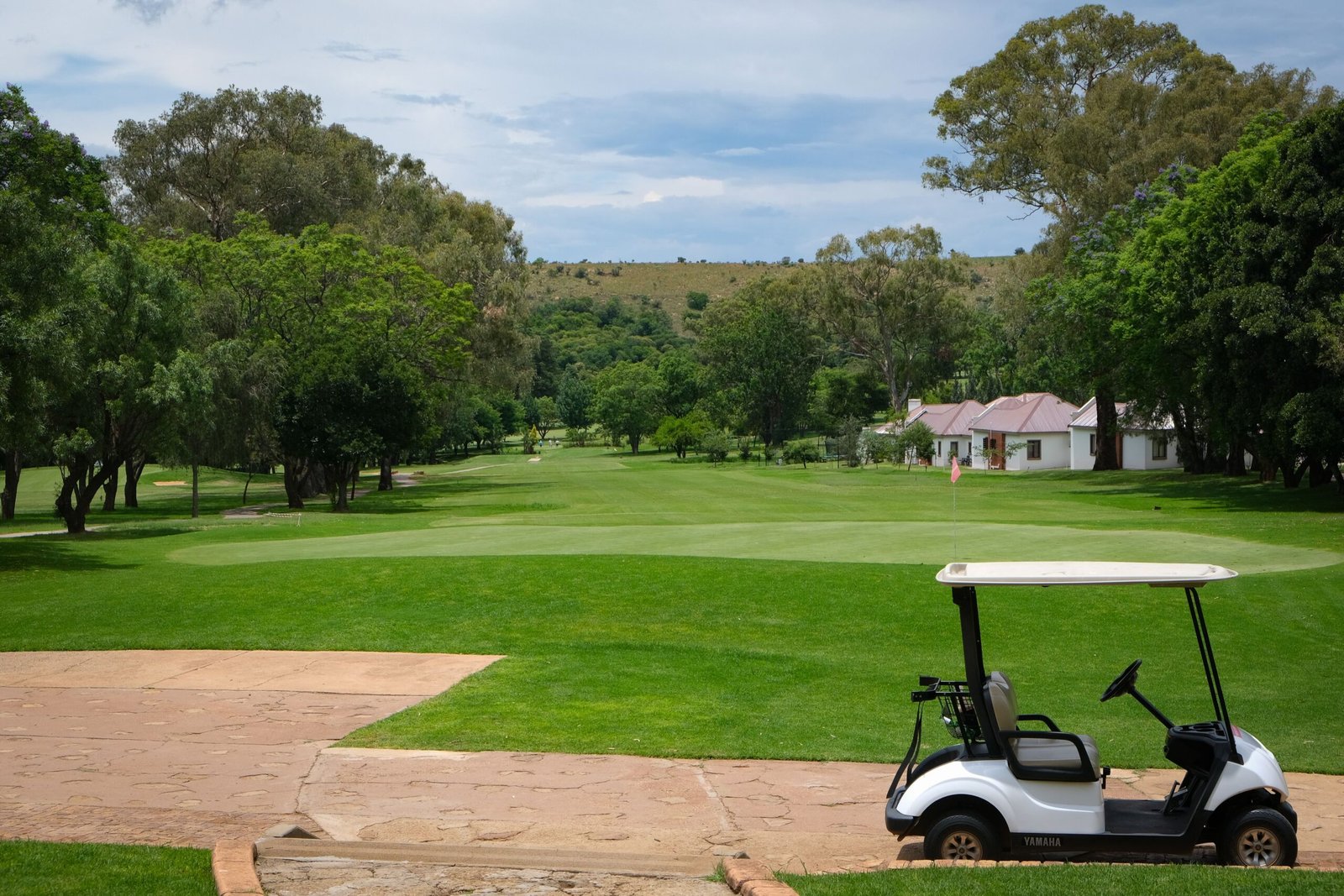 A well-maintained golf cart parked on a quiet course path, regular charging habits prevent most golf cart charger problems