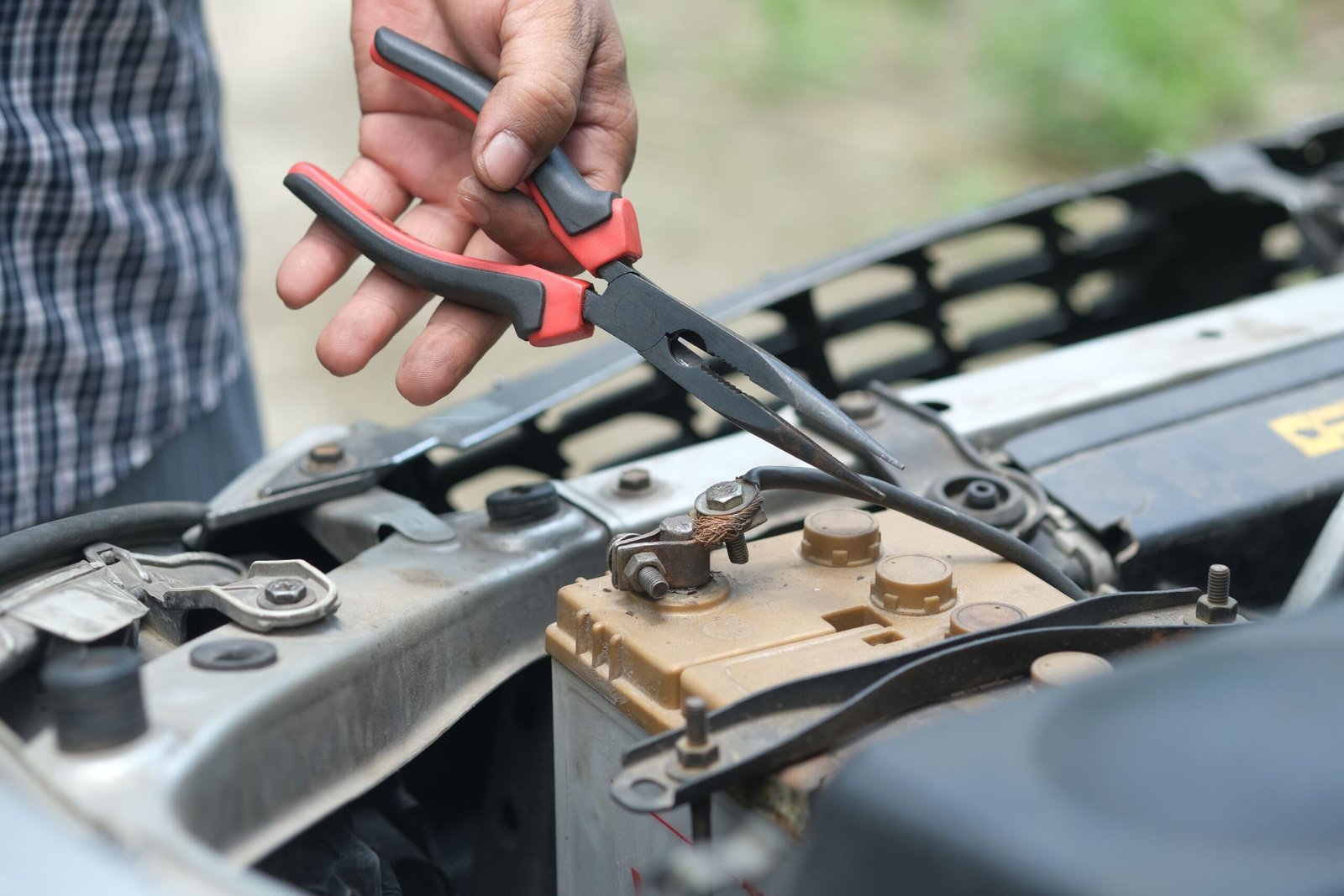 Checking a battery terminal for corrosion, a common reason a golf cart charger will not engage