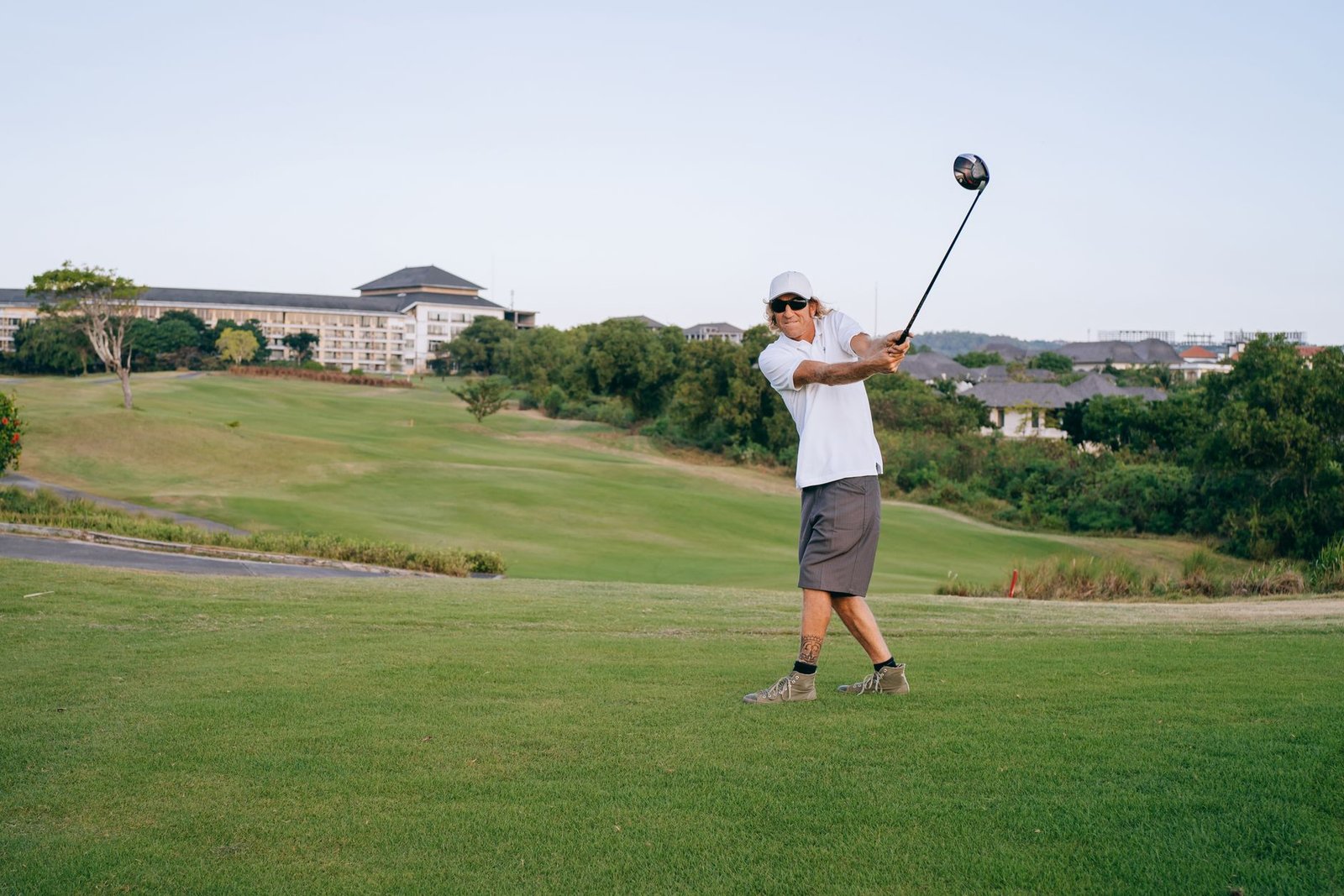 Golfer completing a full swing follow-through on the course