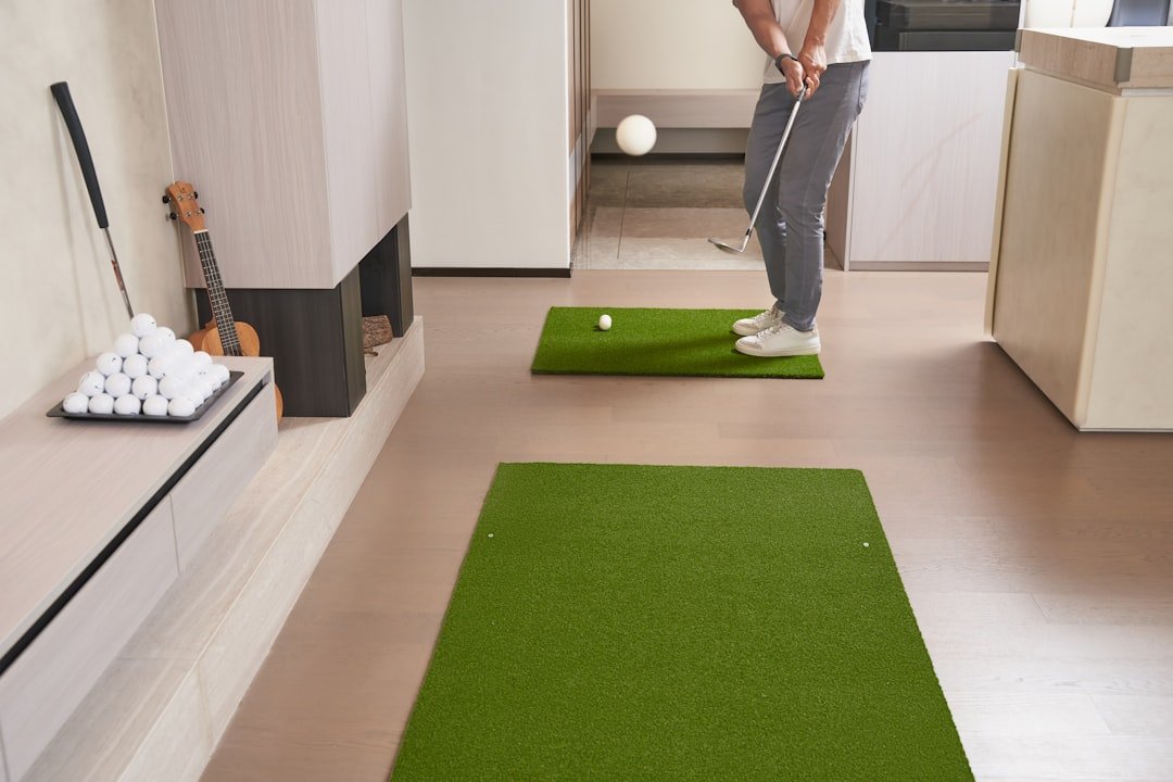 Golfer practicing indoors on a home golf simulator mat setup