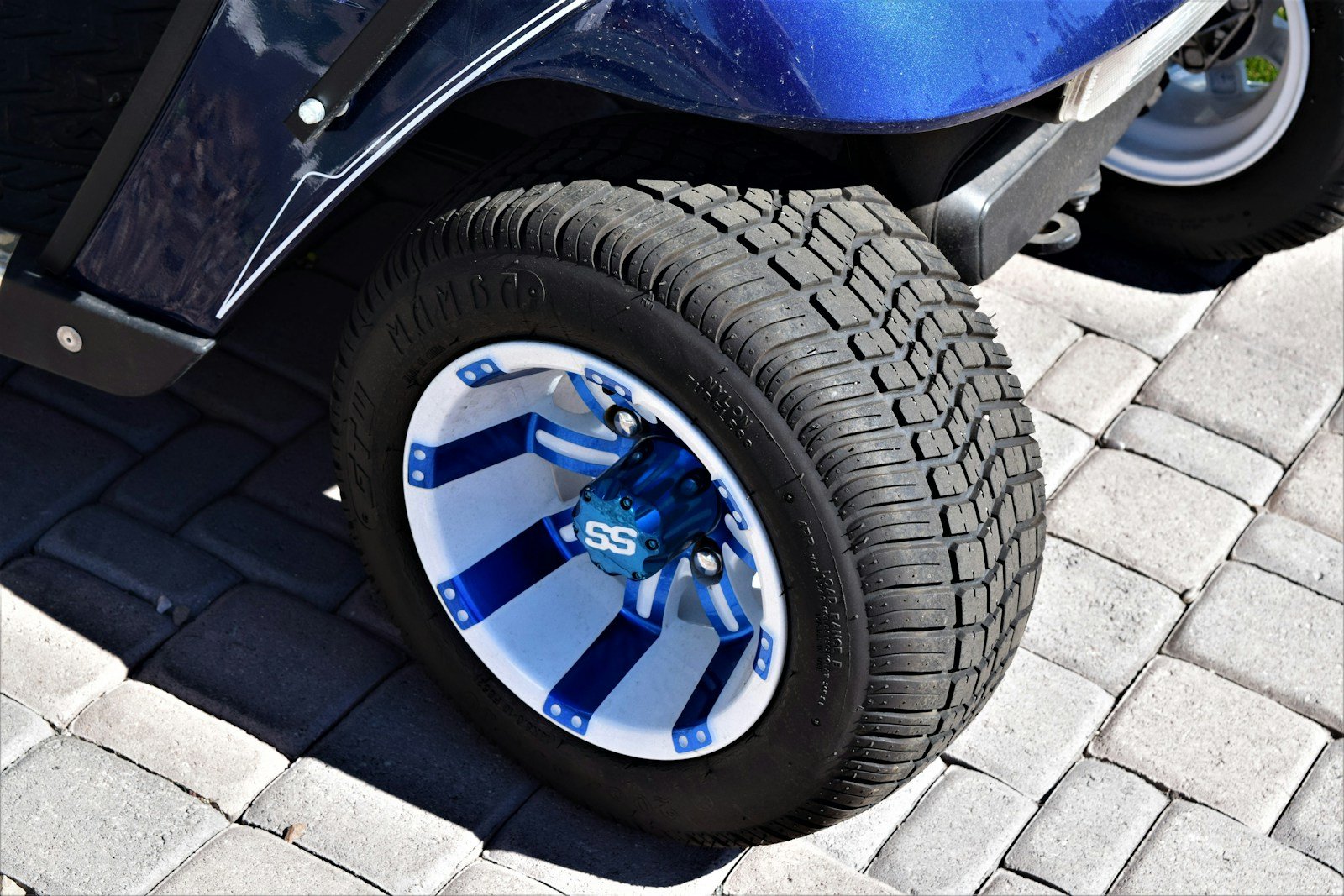 Close-up of a golf cart wheel and tire, where lower tire pressure can shave off a little height