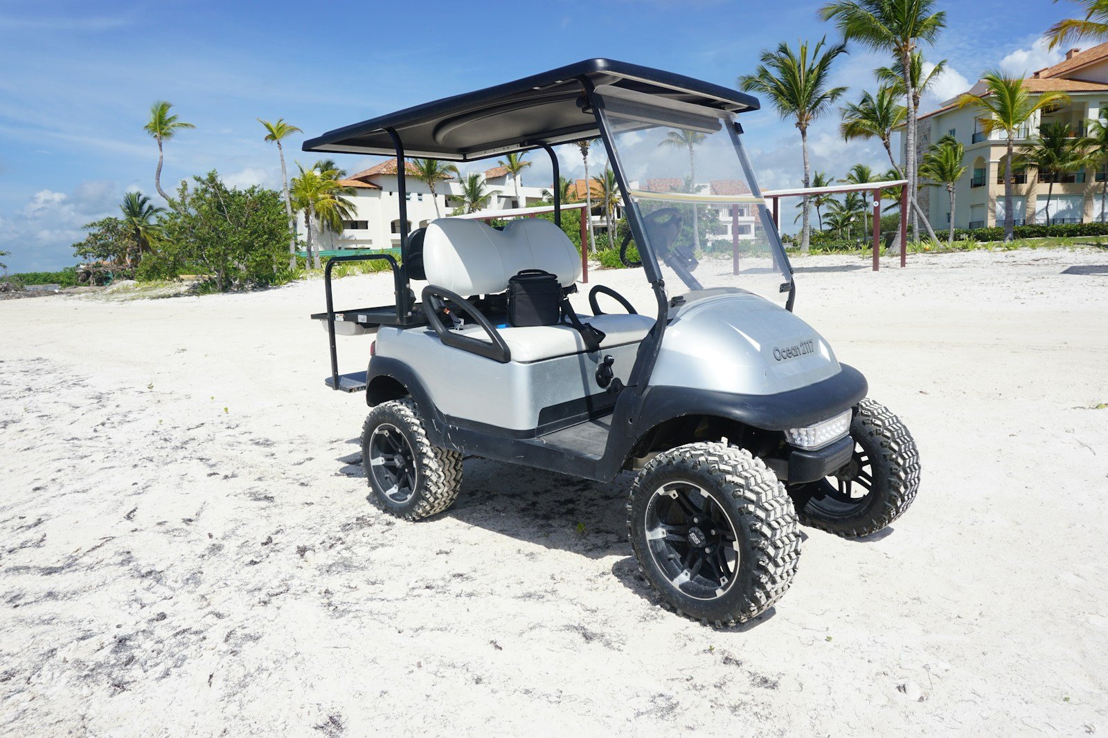 Lifted golf cart with oversized off-road tires, the kind of setup that adds several inches of overall height