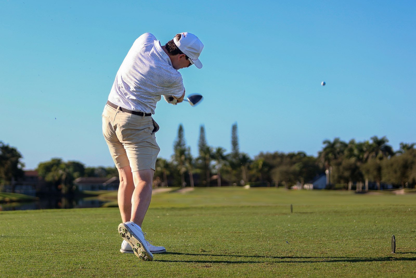 Golfer just after impact with the ball already in flight, moving into the P9 golf swing position