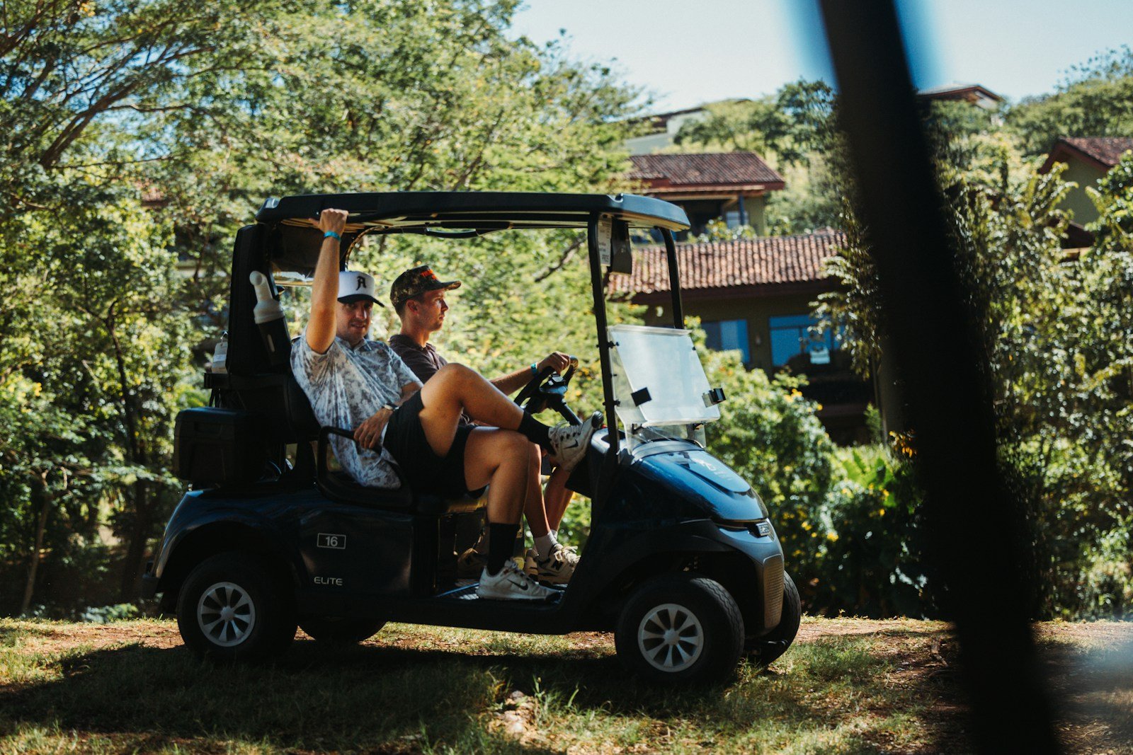 Two friends riding together in a golf cart