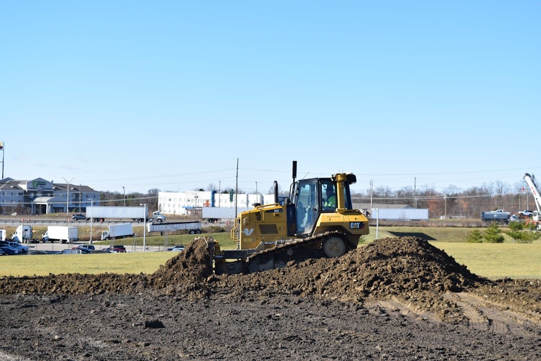A bulldozer moves earth during site excavation, the same heavy equipment work used to shape golf course fairways and greens
