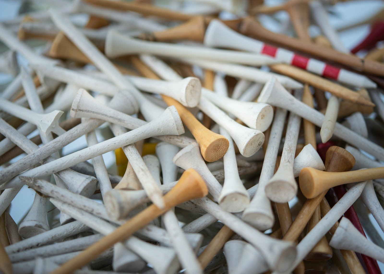 Assorted golf tees in different colors and wood tones, similar to a variety pack that includes purple golf tees