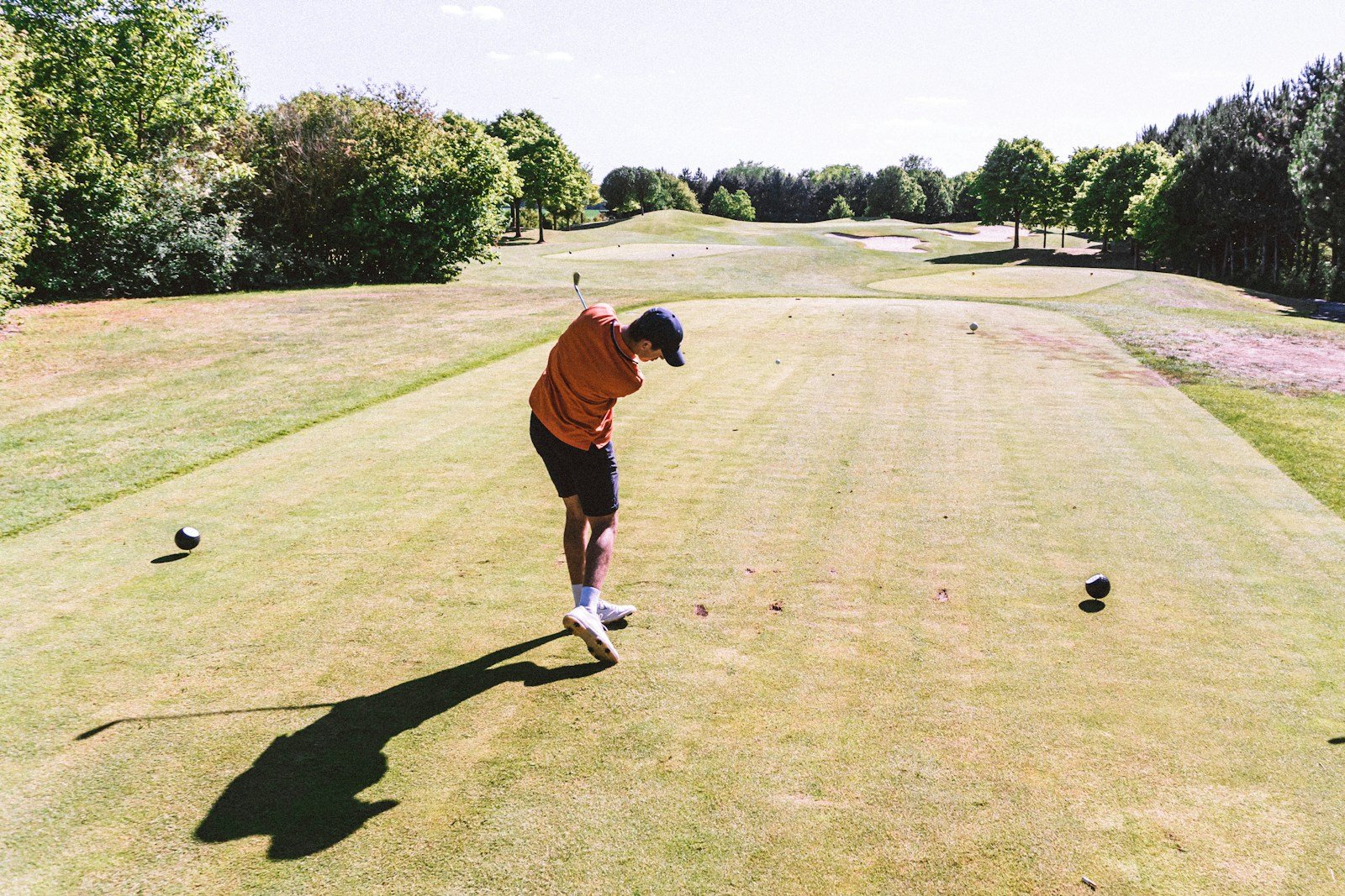 Golfer completing a tee shot on a par 3 hole