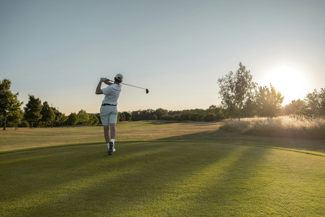 Golfer practicing downswing sequencing on the course at sunset
