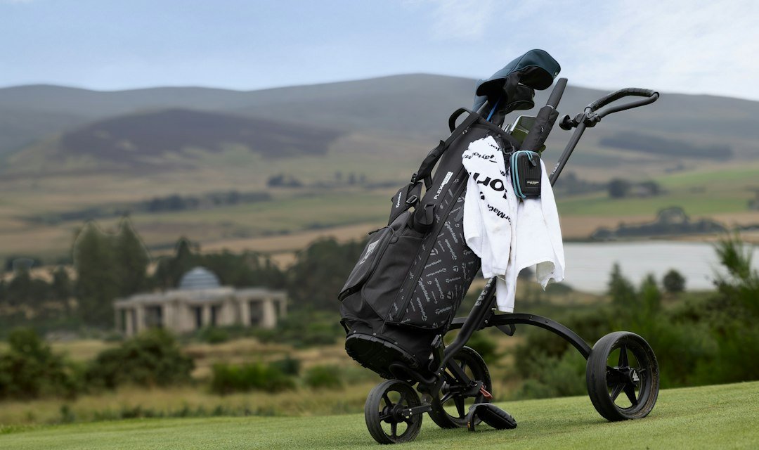 Golf bag on a push cart on a course with rolling hills