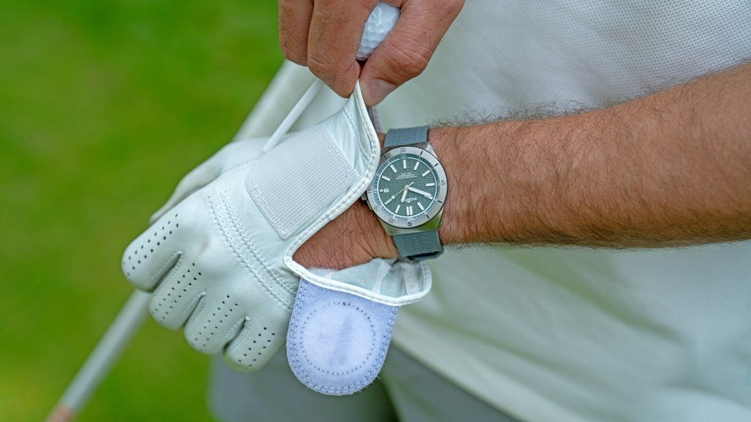 Golfer pulling on a golf glove to check the feel of a fresh set of grips