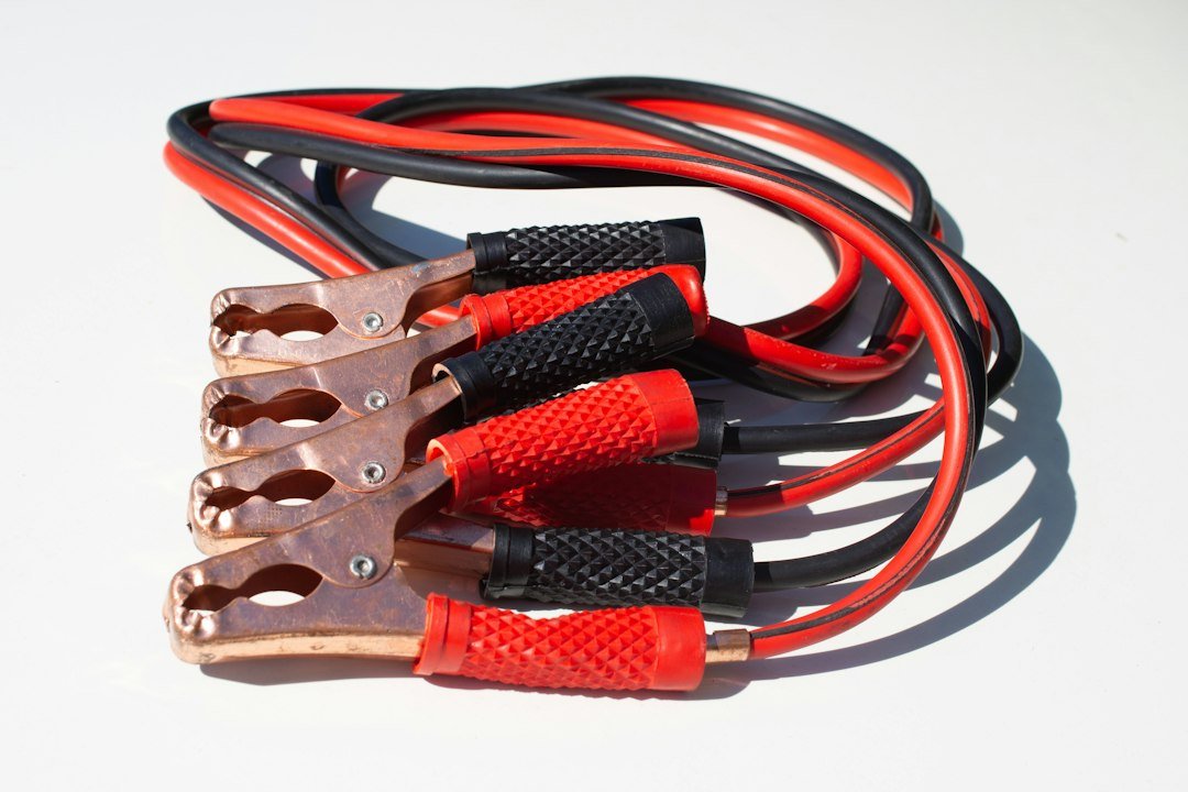 Heavy-gauge red and black battery cables with copper clamps, a reminder to inspect connections first