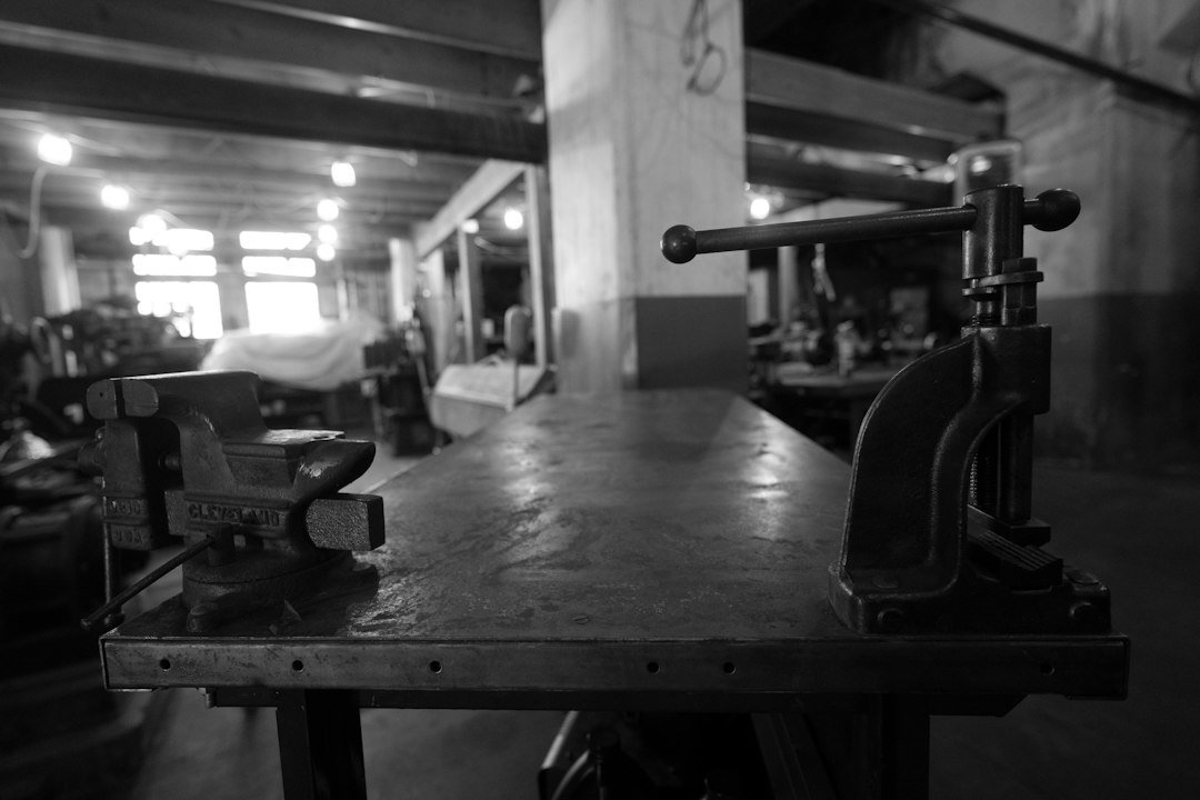 Black-and-white photo of a workshop bench with a vise, the setup for a regrip